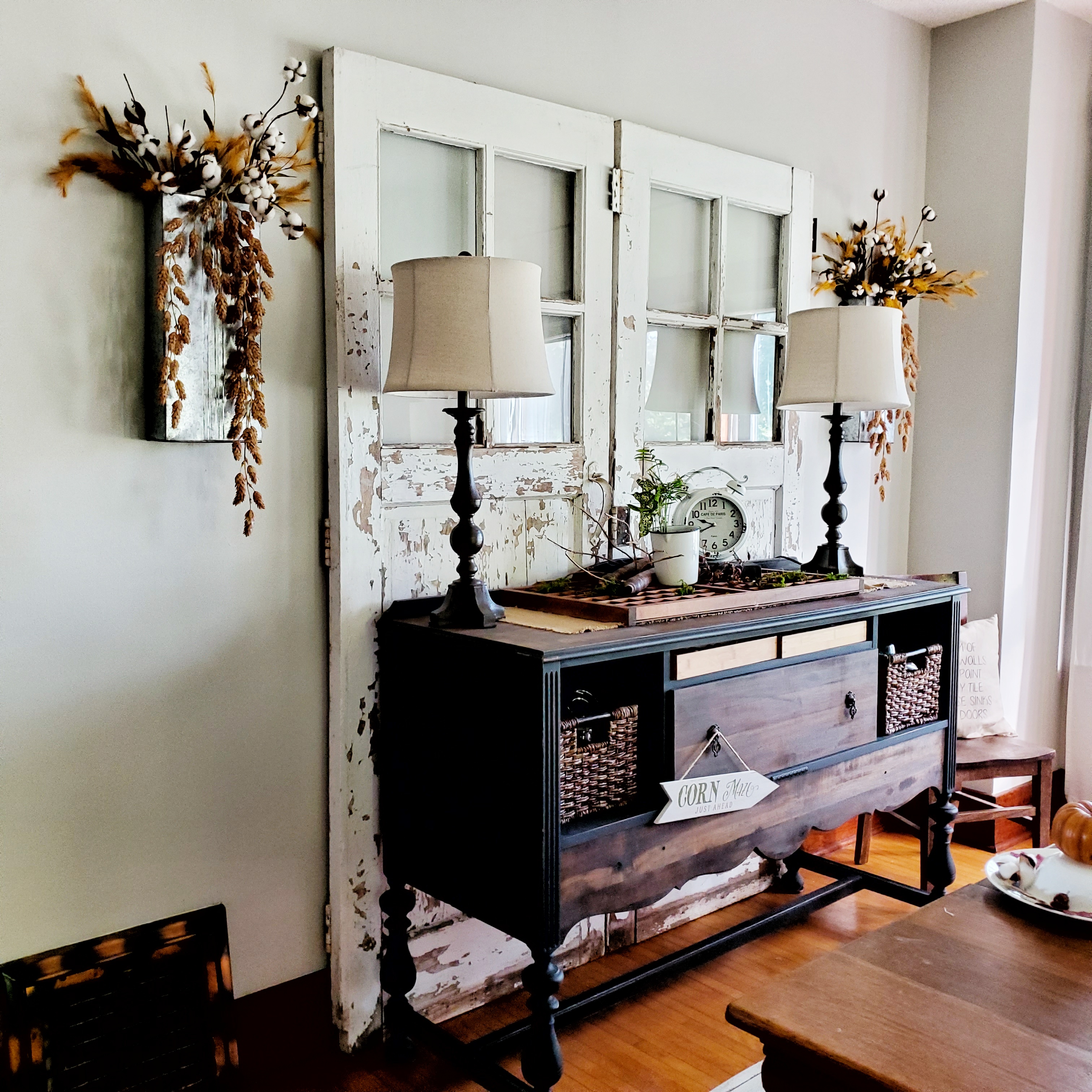 Texture and layers.  Rescued carriage doors layered behind an antique buffet for added drama.  Topped with fall accessories.