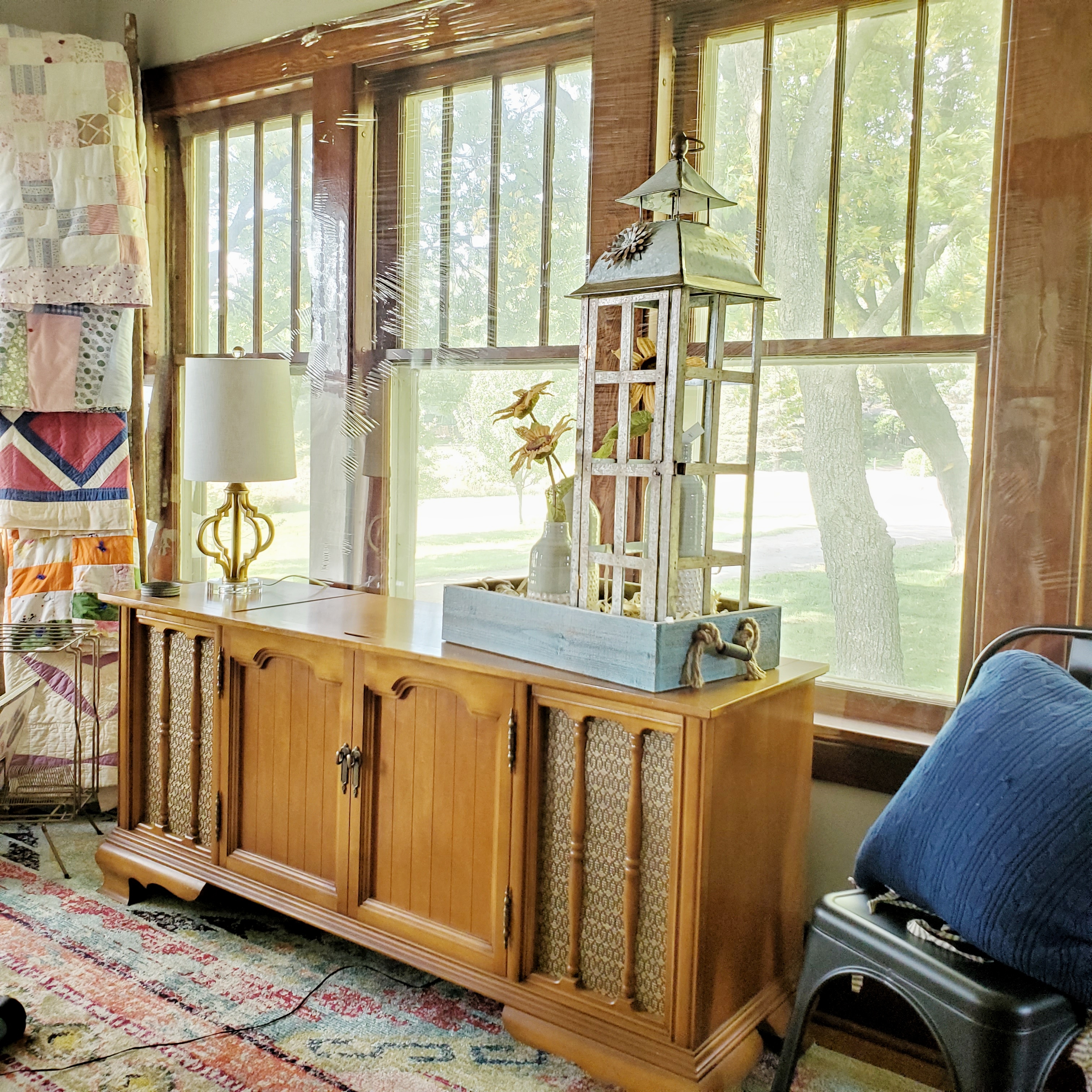 Vintage stereo, barn ladder with quilts and bright boho rug. 