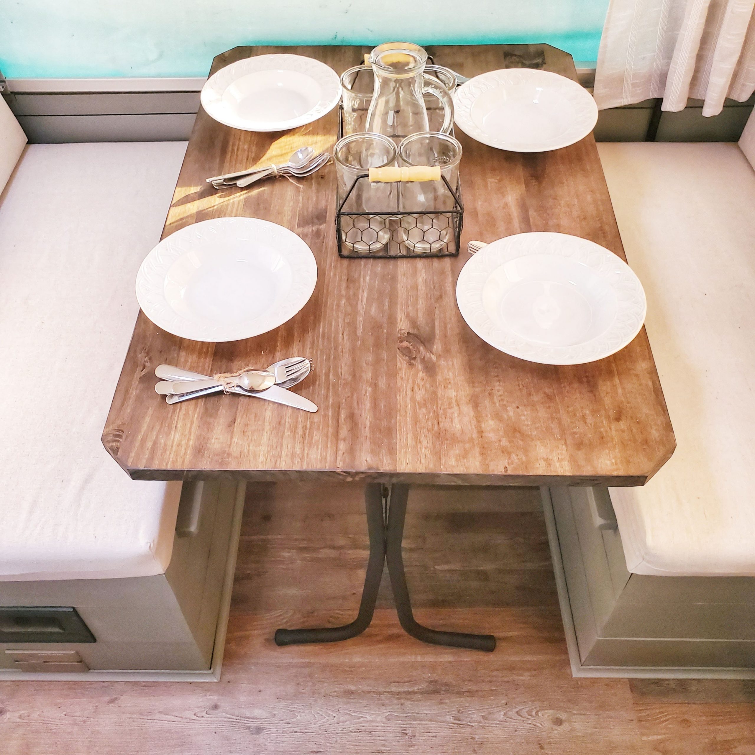 Update your RV with a modern farmhouse look with gray painted cabinets, curtains, a new wood stained table, and updated countertops for less than $500!