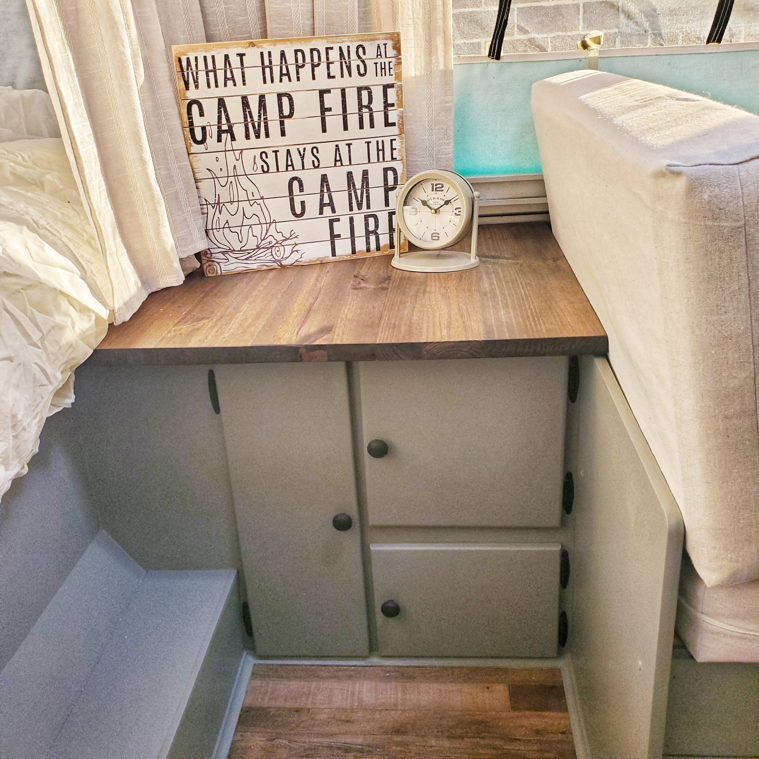 Update your RV with a modern farmhouse look with gray painted cabinets, curtains, a new wood stained table, and updated countertops for less than $500!