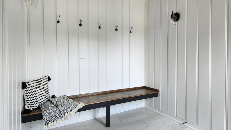 Cute farmhouse style mudroom with painted paneling.