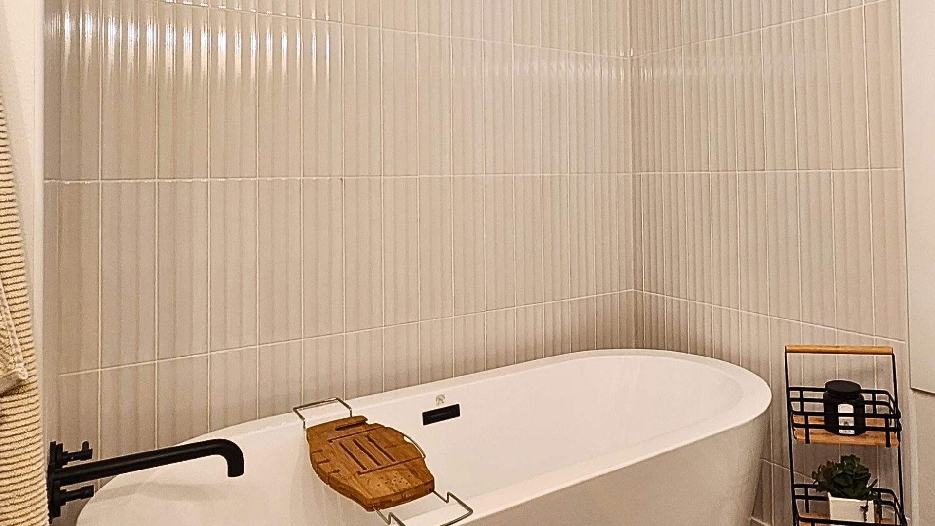 Modern bathroom with vertical white wall tile surrounding a freestanding tub, installed by MeshedDesigns.<br />
