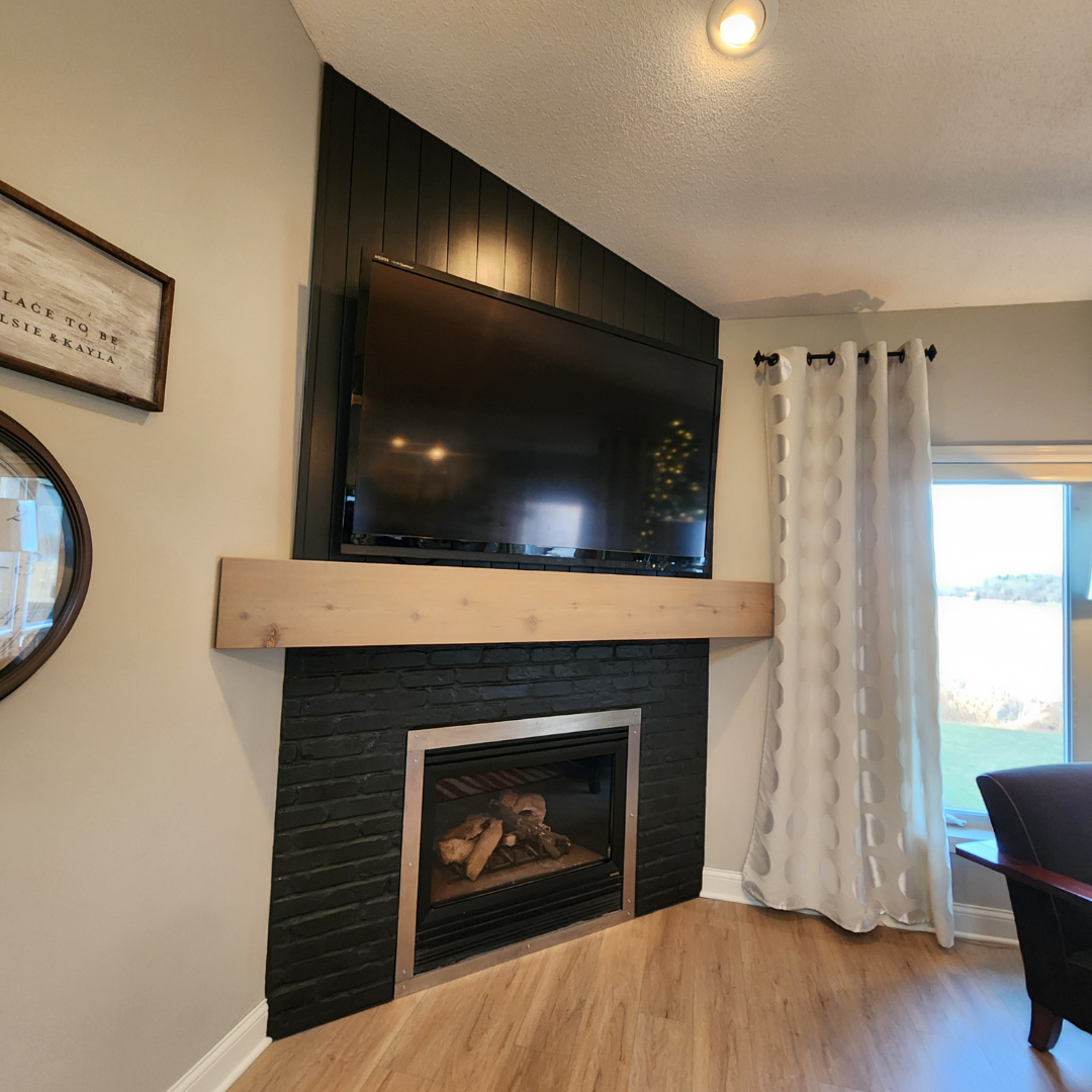 This fireplace went from having a more modern tile surround to a painted black brick with a natural wood mantle.  The look matches the rest of the finishes and color schemes of the home. 