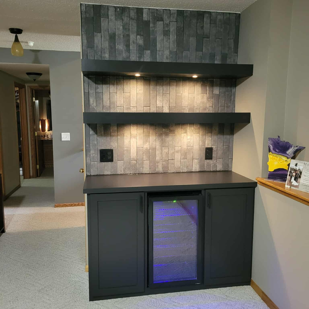 This fireplace went from having a more modern tile surround to a painted black brick with a natural wood mantle.  The look matches the rest of the finishes and color schemes of the home. 