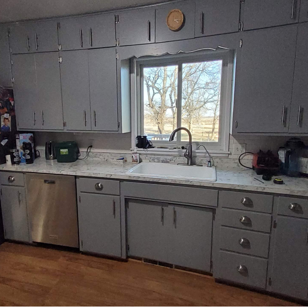 This picture highlights a kitchen ready for a new layout and refresh. It presents a little dark, and could use brightening. There is a peninsula that makes an L that could be changed. 