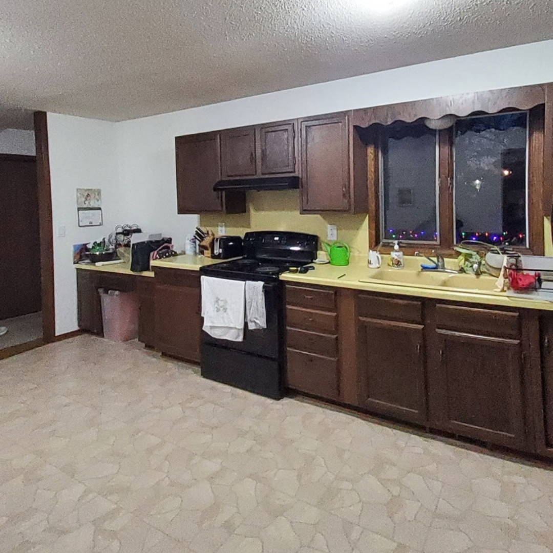 This picture highlights a kitchen ready for a new layout and refresh. It presents a little dark, and could use brightening. There is a peninsula that makes an L that could be changed. 